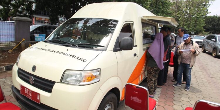SISIR PAJAK: Sejumlah warga membayar pajak di mobil keliling milik Bapenda Kota Bogor di halaman Masjid Al Mutaqqin, Bogor Utara, Senin (9/10). Bapenda melaksanakan operasi sisir Pajak Bumi Bangunan (PBB) untuk jemput bola dan memudahkan pelayanan pajak.