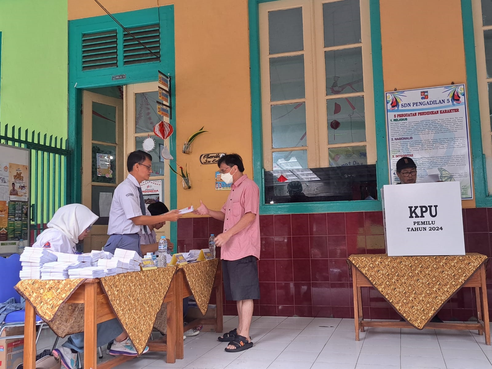 Pakai Seragam SMA : Para KPPS TPS 02, Kelurahan Pabaton mengenakan seragam sekolah menyambut para pemilih, Rabu (14/2).